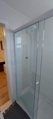 a glass shower in the corner of a room at Ap 154 Balneário Piçarras in Piçarras