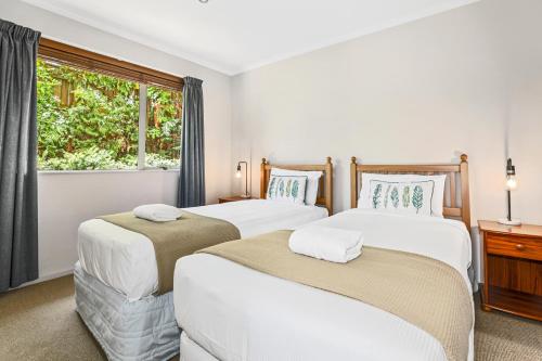 Duas camas num quarto com uma janela em Top of the Lake - Taupo em Taupo