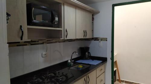 a kitchen with a sink and a microwave at Loft urbano apartamento in Salento