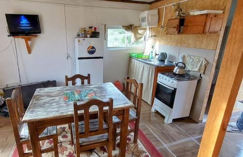 uma cozinha com uma mesa e cadeiras e um frigorífico em Merencere La Esmeralda, Monoambiente a pasos de la playa em La Esmeralda