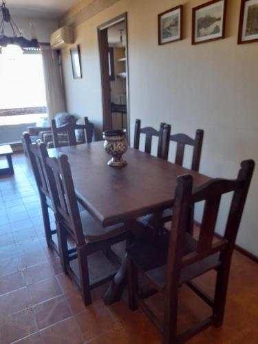 mesa de comedor con sillas y mesa de madera en Edificio Malevo en Villa Gesell