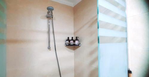 - une douche dans une salle de bains avec des bouteilles sur une étagère dans l'établissement ALDau heights koko, à Hurghada