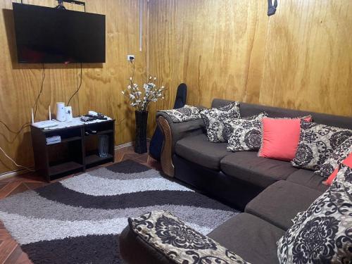 a living room with a couch and a tv at Hospedaje Sra Jenny in Puerto Montt