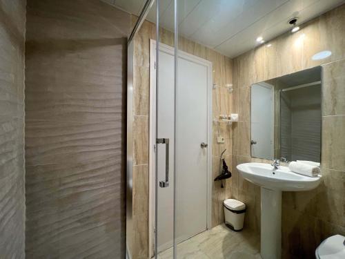 een badkamer met een wastafel en een glazen douche bij Stay U-nique Apartments Gran Via II in Barcelona