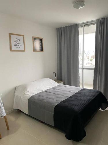 a bedroom with a bed and a large window at El arte suites COCHERA PRIVADA in Buenos Aires