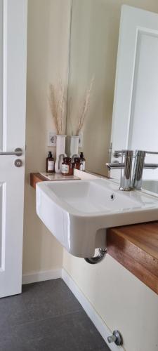 a bathroom with a white sink and a mirror at zona de lagos , barrio country in Colonia Nicolich