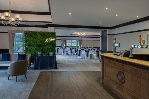 a banquet room with a bar and a table at Delta Hotels by Marriott Breadsall Priory Country Club in Derby