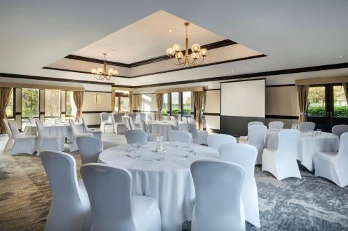 a conference room with white tables and white chairs at Delta Hotels by Marriott Breadsall Priory Country Club in Derby