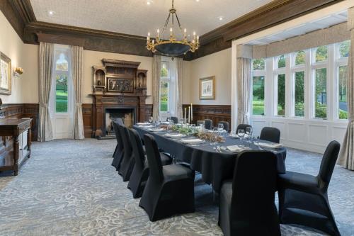 a large dining room with a long table and chairs at Delta Hotels by Marriott Breadsall Priory Country Club in Derby