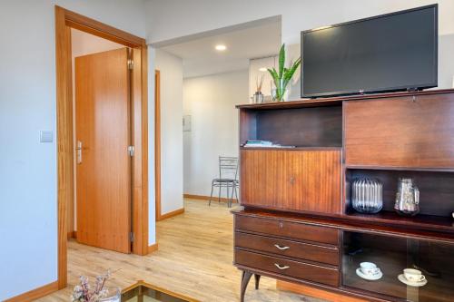 a living room with a television on a wooden entertainment center at Casa Familia Pestana 2, a Home in Madeira in Seixal