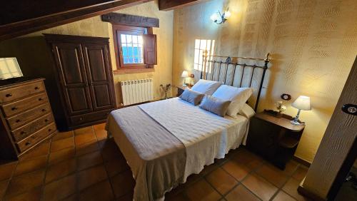 a bedroom with a bed with white sheets and pillows at La Clerecia de Ledesma in Ledesma