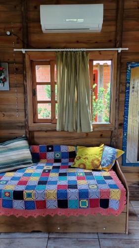 1 cama en una cabaña de madera con ventana en Chalé Tribos Livres en Torres