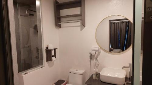 a bathroom with a white toilet and a mirror at Nirili Villa in Dhiffushi