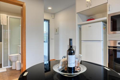 Una botella de vino sentada en una mesa en una cocina en Casa Familia Pestana 2, a Home in Madeira, en Seixal