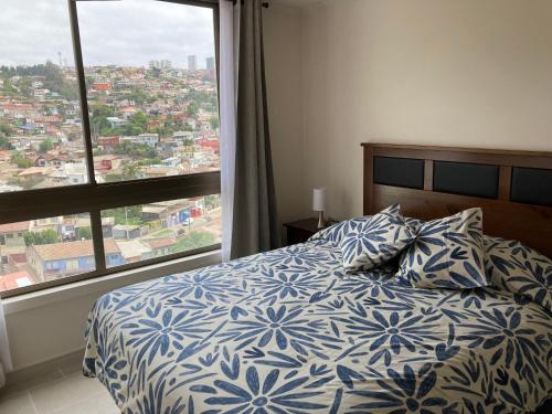 a bedroom with a bed and a large window at Departamento min 3 noches 3 pers Viña del Mar in Viña del Mar