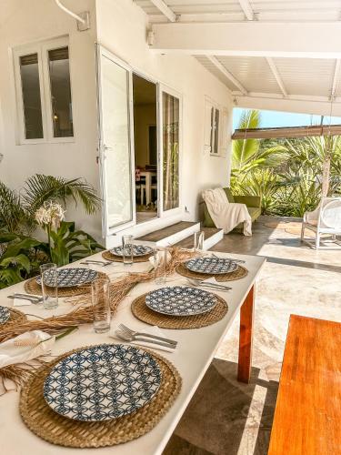 una mesa blanca con platos encima en La villa detente - Une experience authentique, en Rodrigues Island