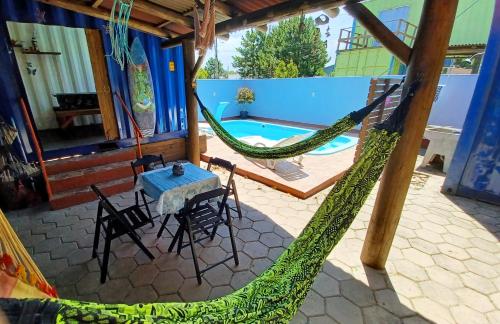 un patio con hamaca, mesa y sillas en Hostel Tribos Livres, en Torres