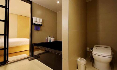 a bathroom with a toilet and a mirror at Jeonju Mari Hotel in Jeonju
