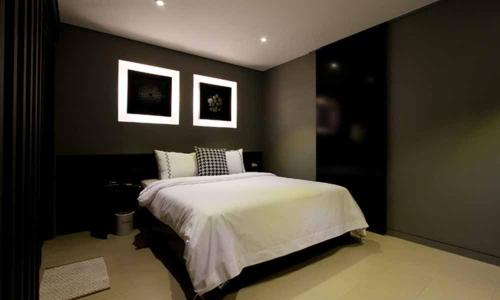 a bedroom with a bed and two pictures on the wall at Jeonju Mari Hotel in Jeonju