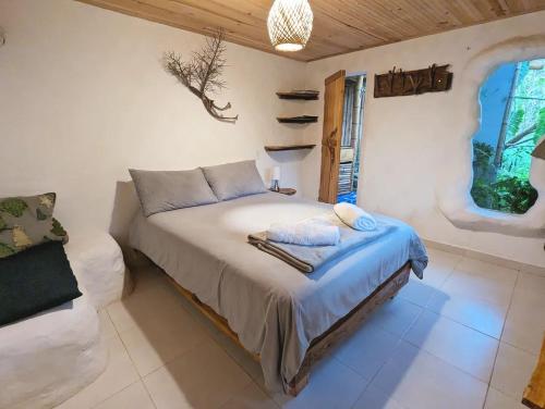 a bedroom with a bed and a window at Finca Flora del Rio, Habitacion Las Orquideas in Pijao
