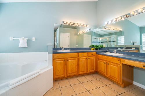 een badkamer met 2 wastafels en een grote spiegel bij 4BR-3BA-Large Private Pool-Free WiFi-Near Disney in Davenport