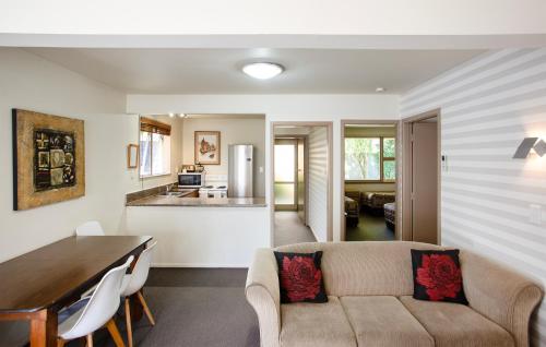 een woonkamer met een bank en een tafel bij Casino Court Motor Lodge in Christchurch
