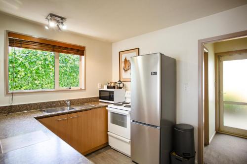 a kitchen with a refrigerator and a stove top oven at Casino Court Motor Lodge in Christchurch