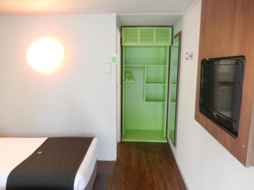 a room with a bed and a tv and a window at Campanile Biarritz in Biarritz