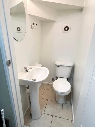 a white bathroom with a toilet and a sink at Casa en Pucón in Pucón