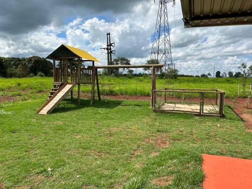 um parque infantil com um escorrega num campo em Casa aconchegante próximo ao Rio Dourados em Dourados