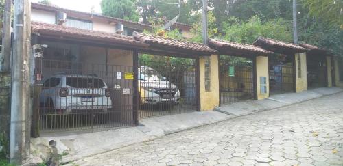 a fence with cars parked inside of a building at Casinhas na Praia do Julião em Ilhabela SP in Ilhabela