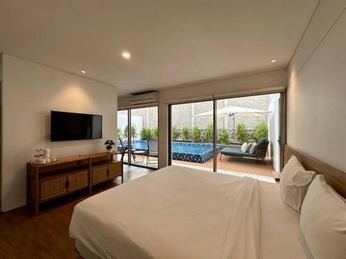 Un dormitorio con una cama grande y un televisor. en Bungalow Homes, en Bandung