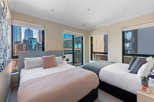 1 dormitorio con 2 camas y ventana grande en Regency Towers, en Melbourne