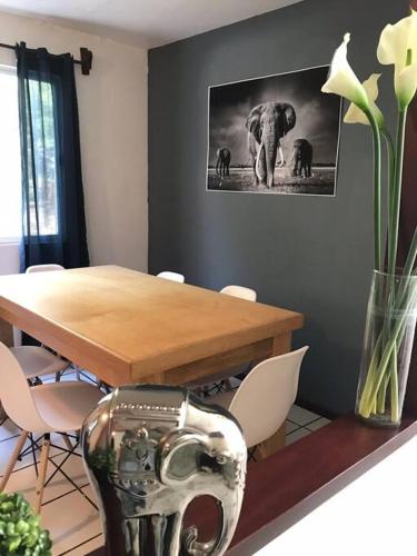 a dining room with a table and a picture of an elephant at Posadas nido del tecolote in Guadalajara