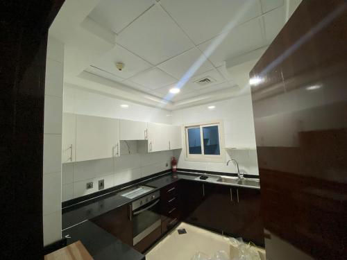 a large kitchen with white cabinets and a window at Striped Partition Room in Barsha 1 Near Mall of the Emirates in Dubai