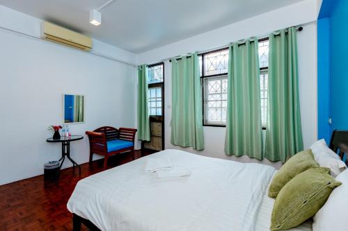 um quarto com uma cama branca e cortinas verdes em iTalay Krabi em Ban Suan