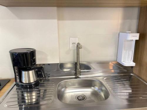 a kitchen sink with a coffee maker on it at Excelente AP (novo) Praia Brava. in Itajaí