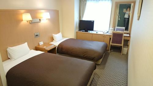 Una cama o camas en una habitación de Sapporo Classe Hotel