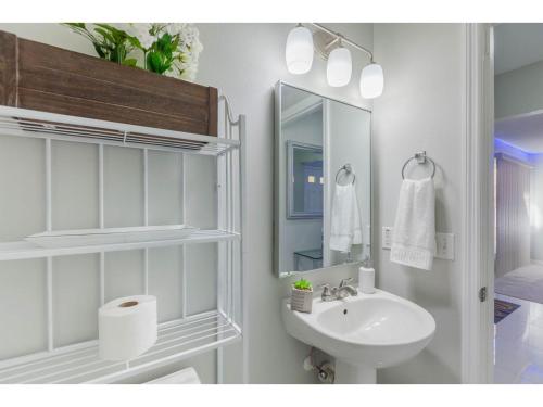 a white bathroom with a sink and a mirror at Themed 6BD Home with Pool - Near Orlando Attractions in Kissimmee