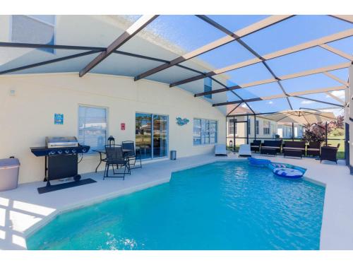 a swimming pool in a house with a roof at Themed 6BD Home with Pool - Near Orlando Attractions in Kissimmee