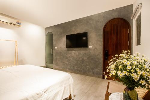 a bedroom with a bed and a tv on a wall at Lanha Hotel - Homestay in Hanoi