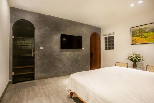 a bedroom with a bed and a tv on a wall at Lanha Hotel - Homestay in Hanoi