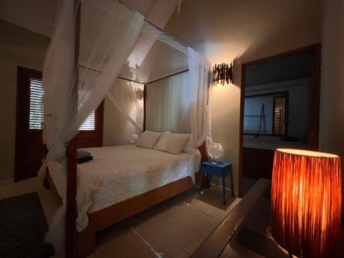 um quarto com uma cama de dossel branca e um candeeiro em Las Terrenas - Caribbean Villa for 6 people - Exceptional location em Las Terrenas