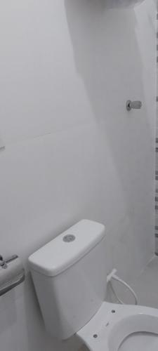 a white bathroom with a toilet and a sink at Lugar de paz! in Marataizes