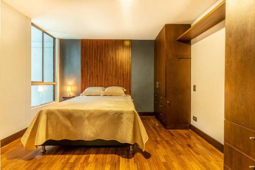 a bedroom with a bed with a yellow bedspread at Apartamento familiar con jacuzzi El Poblado in Medellín