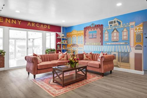 ein Wohnzimmer mit 2 Sofas und einem Wandbild in der Unterkunft The Disneyland Dream: Arcade, Theater, Play, Golf+ in Garden Grove