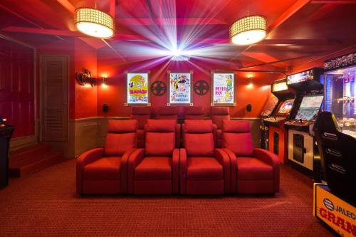 ein Zimmer mit einer roten Couch in einem Videospielzimmer in der Unterkunft The Disneyland Dream: Arcade, Theater, Play, Golf+ in Garden Grove