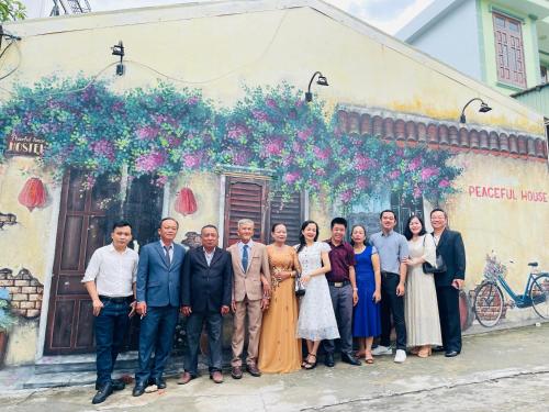 um grupo de pessoas em pé em frente a um edifício em Peaceful House Hostel em Dong Hoi