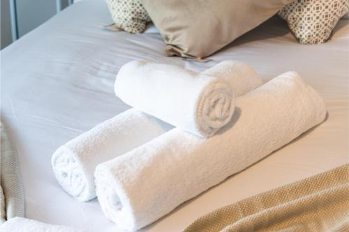 a bunch of rolled towels on a bed at Sweet and Lovely 2BR with Free Parking in London