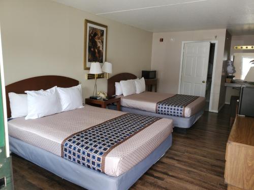 Cette chambre comprend deux lits et une télévision. dans l'établissement Branson King Resort, à Branson